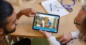 patient with a doctor and a tablet with the GreenLight Mobility website pulled up