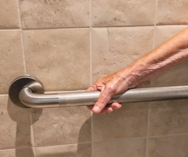 old man holding onto grab bar